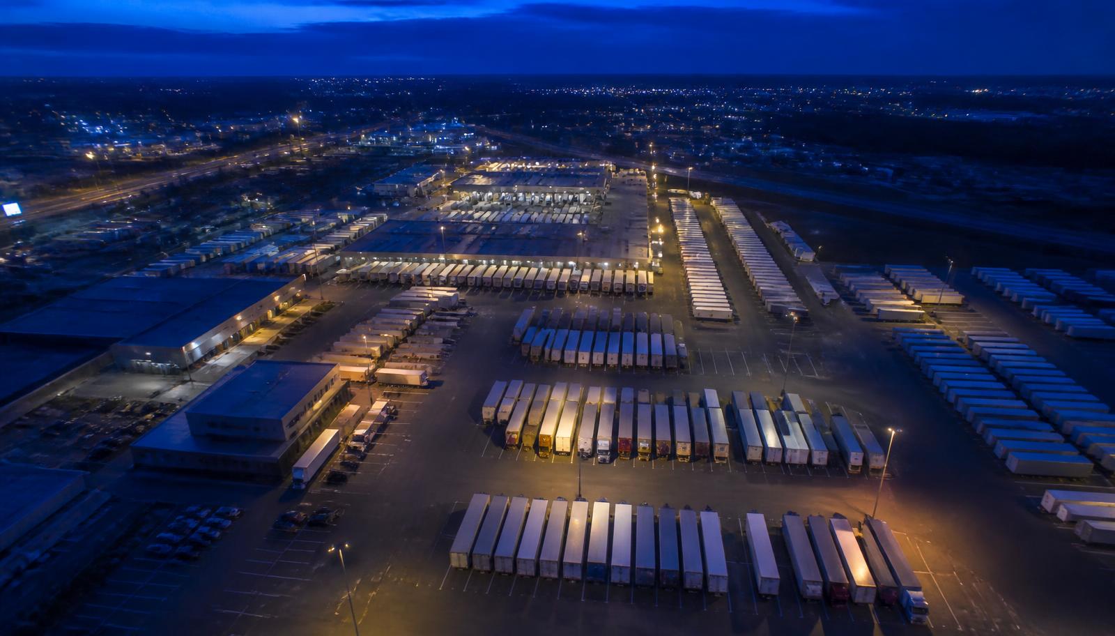 Aerial view of a freight terminal with trucks and trailers at loading docks